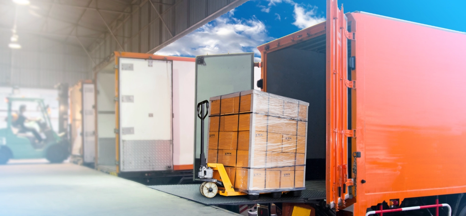 Trucks docking at a warehouse and a forklift driver loading cargo into a container, showcasing efficient freight management made possible by CloudConnect’s Native NetSuite LTL Integration.