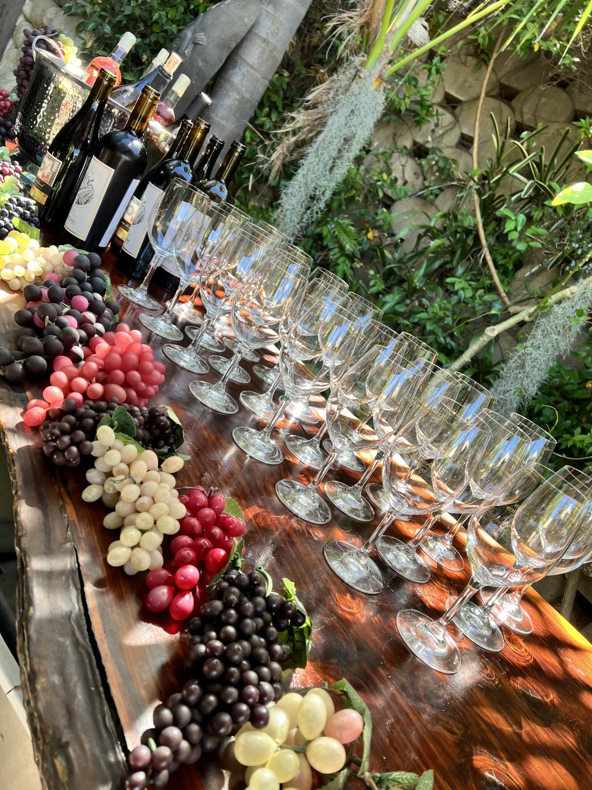 Table at the Sip & Ship event with NetSuite and eHub featuring an assortment of wine bottles, glasses, and clusters of grapes.