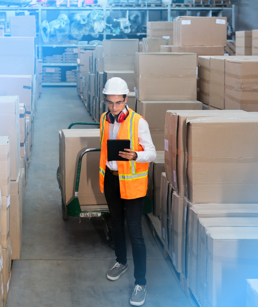 Logistics warehouse worker delivering boxes on a trolley, viewing CloudConnect's EDI Order Automation benefits.