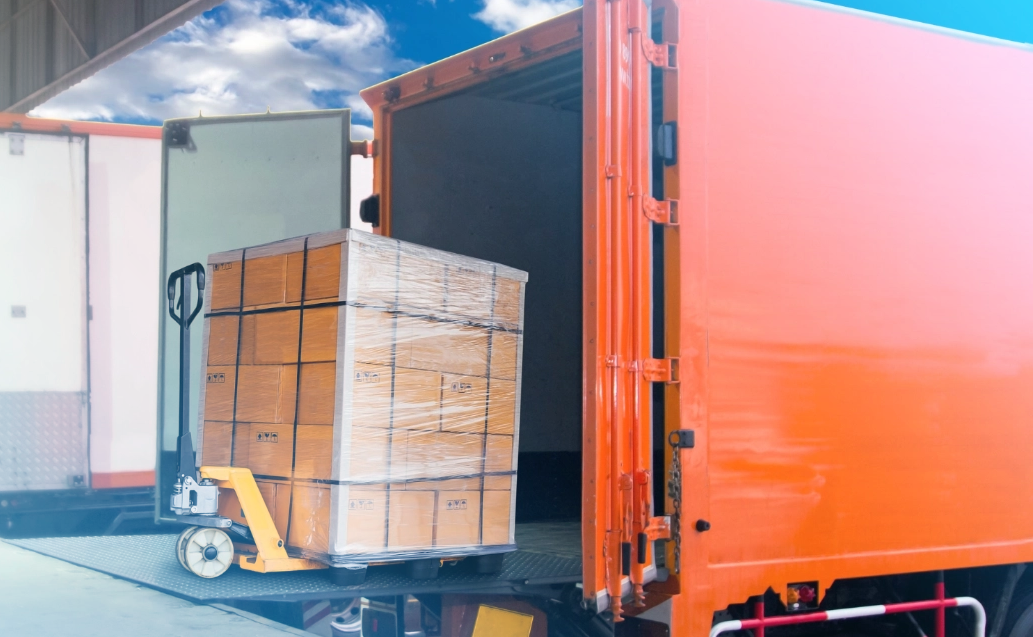 Trucks docking at a warehouse and a forklift driver loading cargo into a container, showcasing efficient freight management made possible by CloudConnect’s Native NetSuite LTL Integration shipping solution.